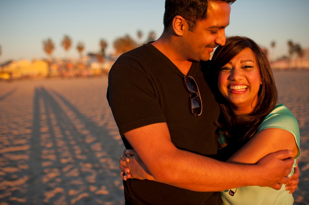 kavita and hemal hugging on the beach